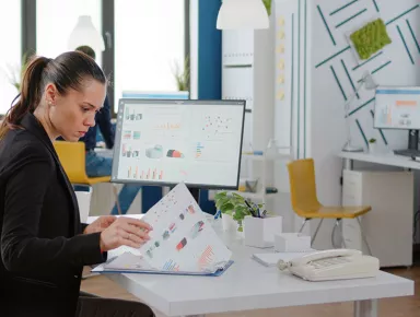 Femme d'affaires travaillant avec des ordinateurs et des graphiques de données sur papier