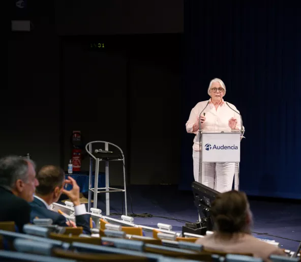 Professor speaking at a microphone in the amphitheatre